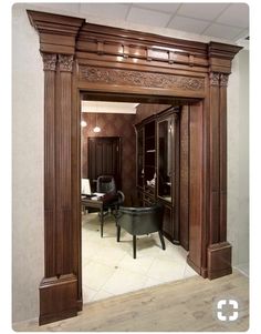 an ornately decorated entry way leading to a sitting area with chairs and desks