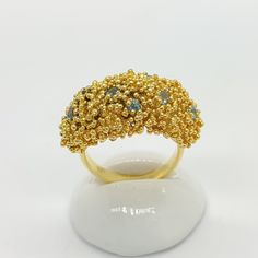 Gold Blue Topaz Ring. Embrace the allure of elegant design with our Handcrafted 24K Gold Vermeil Ring, studded with a captivating Natural Blue Topaz and embellished with granule detailing. A perfect blend of classic artistry and modern style, this piece is sure to add a touch of luxury to any ensemble. Features: Material: 925 Sterling Silver, 24K Gold Vermeil Sterling Silver  Stone: 10 pieces, 2mm  Natural Swiss Blue Topaz. Detailing: Hand-applied granules. Handcrafted: Each ring is uniquely cra Gold Crystal Ring With Stones For Anniversary, Elegant Apatite Rings For Gifts, Elegant Apatite Rings As A Gift, Handmade Apatite Rings For Anniversary, Anniversary Gold Crystal Ring With Stones, Unique Yellow Gold Sapphire Ring With Accent Stones, Gold Aquamarine Gemstone Ring, Gold Rings With Stones Fine Jewelry, Gold Topaz Crystal Ring