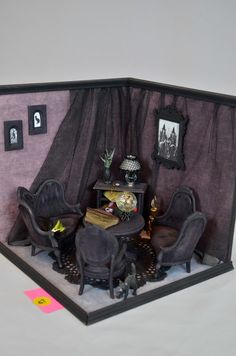 a doll house with furniture and pictures on the walls, including a table and chairs