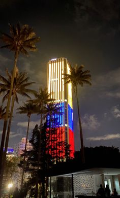 palm trees are lit up in red, white and blue