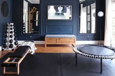 a living room with blue walls and black furniture in it's centerpieces