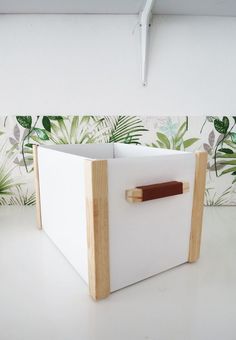 a white box with wooden handles on a table