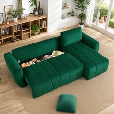 a living room with a green couch and coffee table on the floor next to potted plants