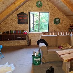 a living room filled with furniture next to a wooden wall covered in wood shingles