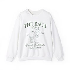 Custom The Bach Club Sweatshirt, Custom Location Bachelorette Sweatshirt, Personalized Bride Sweatshirt, Sweatshirt for Bridal Party 💫Ideal for any situation, a unisex heavy blend crewneck sweatshirt is pure comfort. 💫 Made with a medium-heavy fabric blend of 50% cotton and 50% polyester, this sweatshirt feels cozy and is the perfect choice for those colder months. 💫 Made using 100% ethically grown US cotton. Gildan is also a proud member of the US Cotton Trust Protocol ensuring ethical and sustainable means of production. The blank tee's dyes are OEKO-TEX-certified dyes with low environmental impact. 💫 Fabric blends: Heather Sport colors - 60% polyester, 40% cotton 📢 **Contact us if you need more information:** 👉🏿Designed specifically for individuals, companies, groups, families, o Bride Sweats, Bachelorette Matching, Mexico Bachelorette, Matching Sweat Set, Bride Hoodie, New Year's Games, Yellow Crewneck, Bride Attire, Bride Sweatshirt