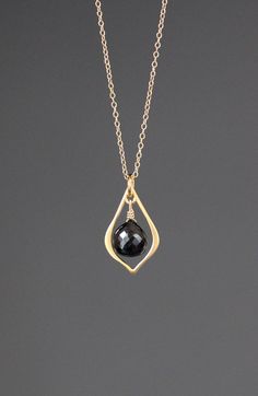 "A sweet faceted Black Spinel teardrop stone is wire wrapped with 14k gold filled wire onto a 24k matte gold vermeil frame.  This pendant dangles from a 14k gold filled chain.  Choose from a 1mm gold chain with a gold spring ring clasp, or a 1.5mm gold chain with a gold lobster clasp. Each chain measures 16\" with an extension to 18\".  Please send a message if a different length chain is desired. This pendant is elegant and suited for any occasion. The combination of black and gold is amazing! Black And Gold Necklace, Black Spinel Necklace, Black Gold Necklace, Spinel Necklace, Headpiece Jewelry, Wire Jewelry Designs, Black Beaded Jewelry, Wire Wrapped Rings, Black Spinel