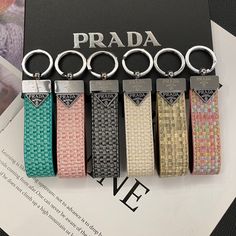 four key chains with different colors and designs on them, sitting next to a book