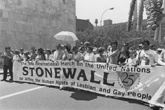 a group of people holding a stonewall banner