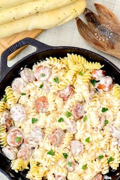 a skillet filled with pasta, meatballs and sauce on top of a table