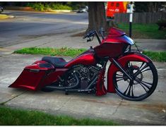 a red motorcycle is parked on the sidewalk