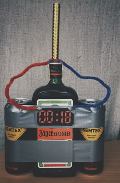 an alarm clock on top of a liquor bottle