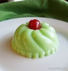 a small green dessert with a cherry on top