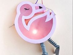 an ornament shaped like a pink flamingo hanging from a hook on a wall