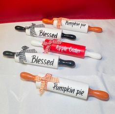 four lip bales with pumpkins on them sitting on a white tablecloth covered table