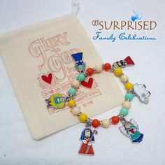 a bracelet with charms on it sitting next to a bag