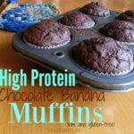 high protein chocolate banana muffins in a muffin pan on a wooden table