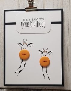 two giraffes with their faces drawn on them are attached to a clipboard