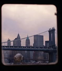 a view of the brooklyn bridge from across the river, looking out through a window