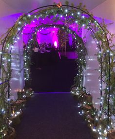 an archway decorated with lights and greenery