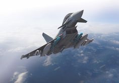 a fighter jet flying through the sky above clouds