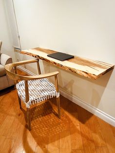 a wooden table sitting on top of a hard wood floor next to a white chair