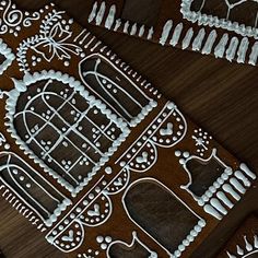 gingerbread cookies decorated with white icing and decorative decorations on top of a wooden table