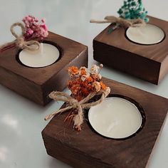 three square wooden coasters with candles in them