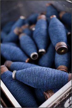 several blue spools of thread sitting in a box