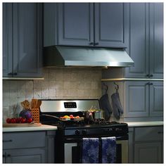 a stove top oven sitting inside of a kitchen next to a counter with utensils on it