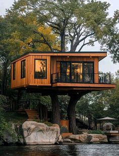 a tree house built into the side of a lake