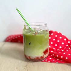 a green drink in a glass with a straw sticking out of it's side