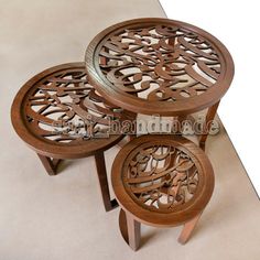 three wooden tables with carved designs on them