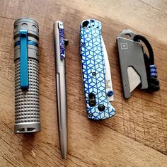 three different types of lighters sitting on a table next to each other and one has a pen in it