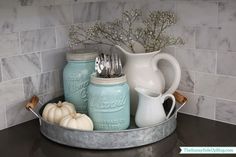 mason jars and utensils are sitting on a tray