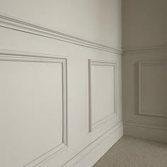 an empty room with white paneling on the walls