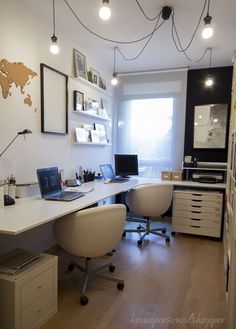 an office with two chairs and a desk in front of a map on the wall