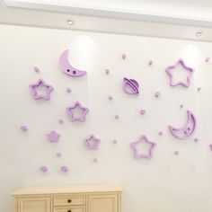 the wall is decorated with purple stars and moon shapes