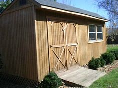 a small wooden shed sitting in the grass