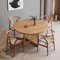 a wooden table with four chairs and a vase on it in front of a painting