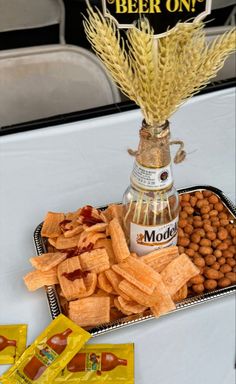 there is a tray with snacks and beer on it