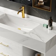 a bathroom vanity with a marble counter top and gold faucet handles on it