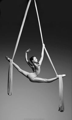 a woman is doing aerial acrobatics in the air