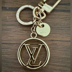 a close up of a keychain on a wooden surface with the letter w