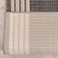 three different rugs on the floor with white and grey colors, one is gray