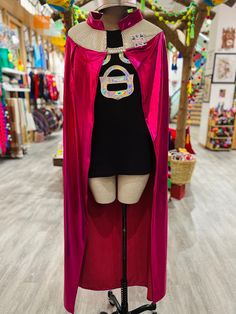 a mannequin dressed in a pink cape and black shirt with the number six on it