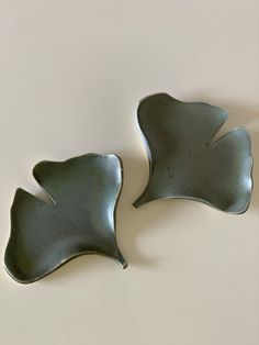 two green dishes sitting next to each other on a table