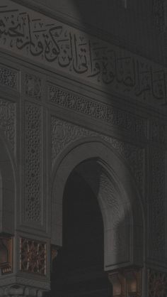 an ornate archway with arabic writing on the wall and below it is a light that shines through