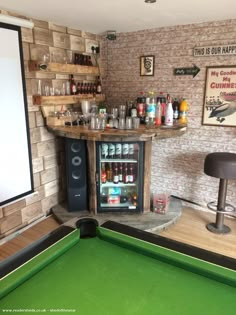 a pool table in a small room with an entertainment center and shelves on the wall