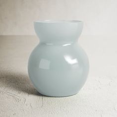 a white vase sitting on top of a table