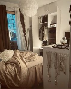 a bedroom with an open closet and clothes on the shelf, next to a bed